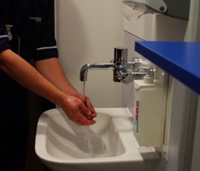 写真1：個室へ入る前に手を洗う看護師
