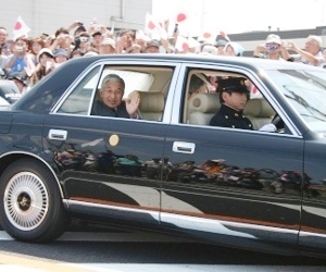 車内から手をふってこたえる天皇陛下