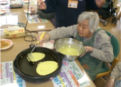 ホットケーキを焼くため、ホットプレートに生地を乗せるご利用者さん